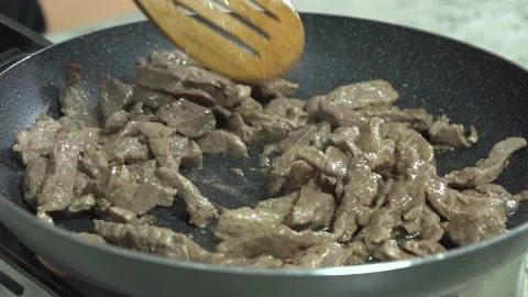 Cooking raw beef in a black pan, close up Stock Footage 154282949