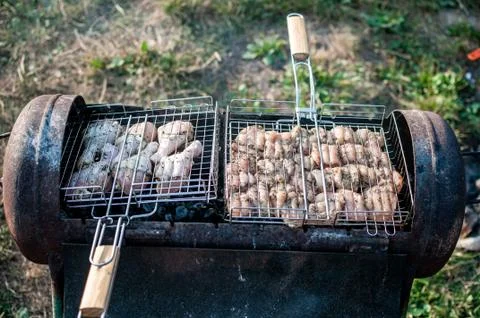Cooking raw meat in a grid on the barbeque grill Stock Photos