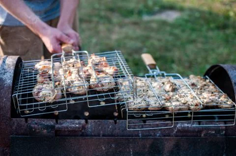 Cooking raw meat in a grid on the barbeque grill Stock Photos