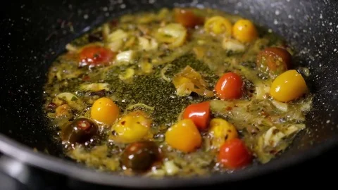 Cooking red and yellow tomatoes in the frying pan Stock Footage 77002745