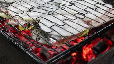 Cooking red fish on fire with lemon and onion and herbs Stock Footage 134198978