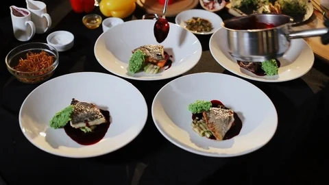 Cooking In Restaurant. Four Plates On Table With Dishes. Chef Pours The Sauce. Stock Footage 120575421