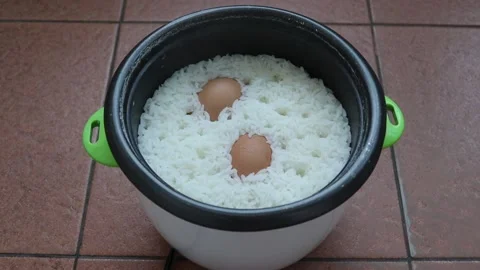 Cooking rice and boiling eggs in electric rice cooker open the lid Stock Footage 144478818
