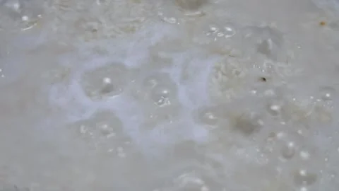 Cooking rice in a black pan, stirring using a wooden spatula Stock Footage 304721829