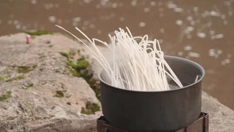 Cooking Rice Noodles with Backpack Kitchen Next to River, Close Up Stock Footage 242481712
