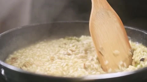 Cooking risotto with mushroom in the frying pan, slow motion. Stock Footage 154370565