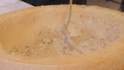 Cooking risotto in parmesan cheese bowl, italian cuisine concept. Chef preparing Stock Footage 172265348