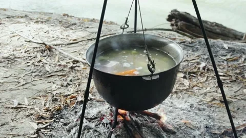 Cooking river fish soup in a cauldron on a fire on the river bank 스톡 동영상 254062254