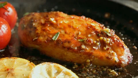 Cooking roasted chicken breasts with lemon tomato  pour oil spice close up Stock Footage 88929972