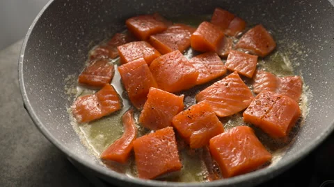 Cooking roasted pieces of salmon or trout fish in hot a pan Stock Footage 220084872