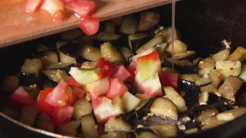 Cooking roasted vegetables. Chef stirs with spoon into steaming hot pan 스톡 동영상 250772708