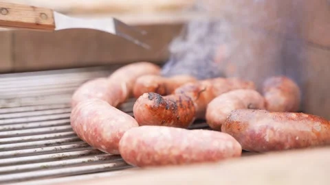 Cooking sausages BBQ using a fork on a grill. Barbecue. Sizzling. Stock Footage 254797306