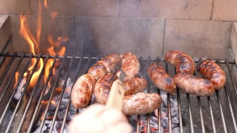 Cooking sausages BBQ using a fork on a grill. POV shot. Stock Footage 254797440