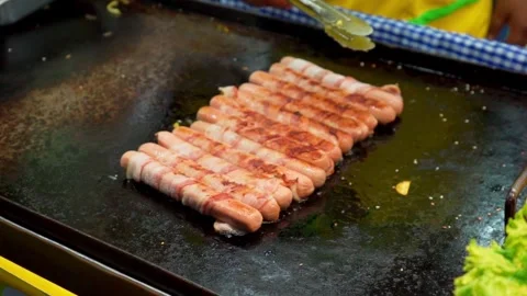 Cooking sausages on a griddle Stock Footage 295401686