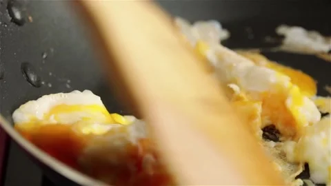 Cooking scrambled eggs in frying pan close view Stock Footage 113755786