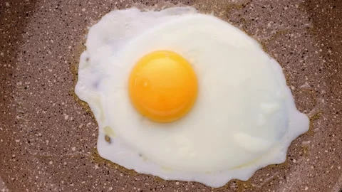 Cooking scrambled eggs in frying pan. Top view, selective focus. Timelapse. Stock Footage 149814155