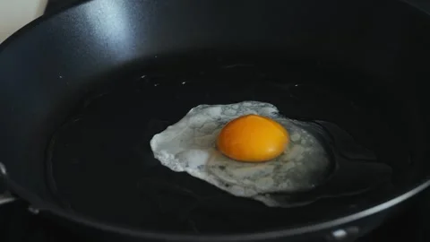 Cooking scrambled eggs in a frying pan, preparing breakfast at home. Stock Footage 314450929
