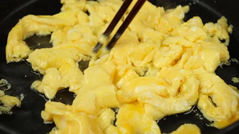 Cooking scrambled eggs, omelette. Preparation breakfast food on pan Stock Footage 236286319
