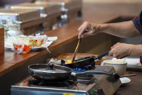 Cooking scrambled eggs on pan Stock Photos