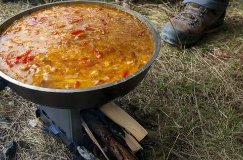 Cooking scrambled eggs with vegetables on the fire in the woods Stock Photos