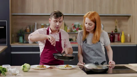 Cooking show hosts chefs, male and female, cooking in the kitchen studio set Stock Footage 130840023