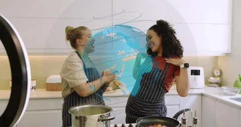 Cooking show hosts greeting camera and stirring steel pot on gas cooktop while Stock Footage 320416233