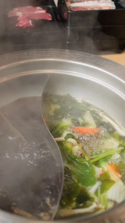 Cooking Sliced Beef in Dual Broth Hotpot at Buffet Table Stockbeeldmateriaal 322148391