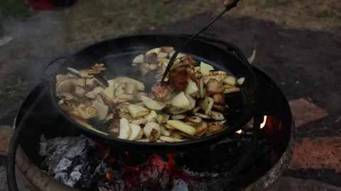 Cooking Sliced Potatoes in a Cast Iron Skillet Over an Open Fire Stock Footage 337105807