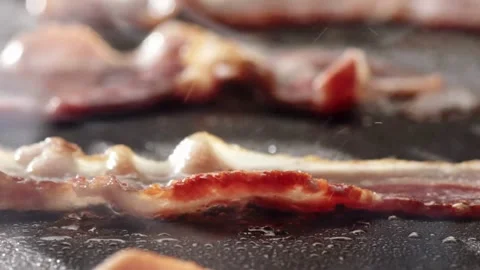 Cooking slices of bacon for breakfast. Bacon Frying in a Pan. 스톡 동영상 334641745