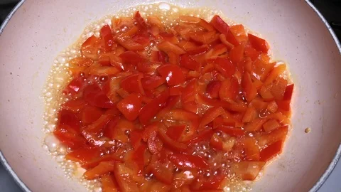 Cooking slices of red pepper with olive oil in a white ceramic pot. Stock-Footage 86131296