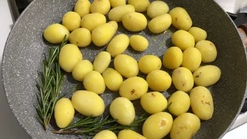 Cooking small spring yellow potatoes with olive oil, rosemary and salt in a pot Stock-Footage 86131649