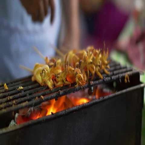 Cooking small squids on the grill at night street fair Stock Footage 69716346