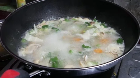 Cooking soup in a black pan with boiling water Stock Footage 307558064