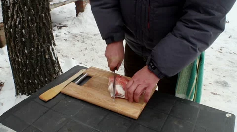 Cooking soup from lamb in a cauldron. A man cutting mutton fat on chopping board Stock-Footage 63660717