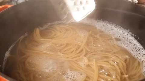 Cooking spagetti inside boiling water, iron cast pot, close up Stock Footage 205328173