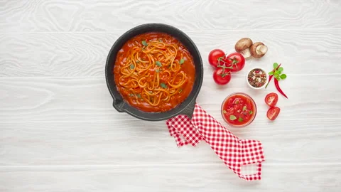 Cooking spaghetti with tomato sauce in cast iron pan served with red chili Stock Footage 130463466