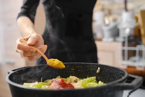 Cooking with spices in a modern kitchen during a flavorful meal preparation Foto stock