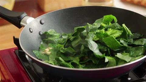 Cooking spinach  in frying pan close up Stock Footage 109037666