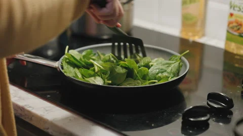 Cooking spinach on stovetop Stock Footage 141701857