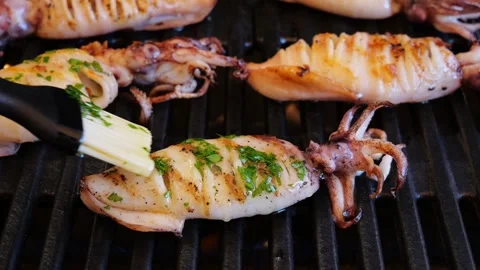 Cooking squids on grill, brush with olive oil and spices. Slow Motion. Close up Stock Footage 252930616