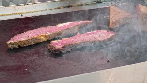 Cooking steak on a grill with bread slices in a local kitchen Stock Footage 340461988