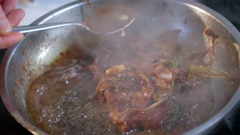Cooking steak in pan in the kitchen at home. Chef pours oil on steak by spoon. Stock Footage 233620209