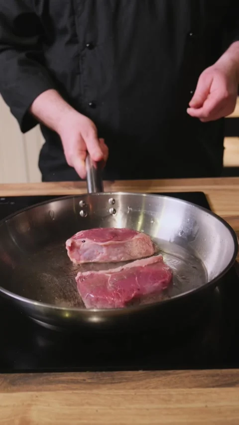 Cooking steaks in an iron pan Stock Footage 305305750