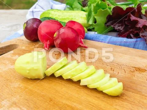 Cooking summer vegetable salad. Cutting cucumbers close-up Stock Photos