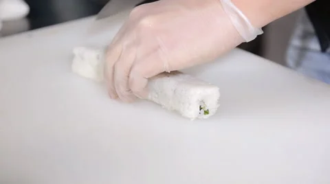 Cooking sushi rolls in the studio. cut into portions, the master hands in gloves Video stock 59356408
