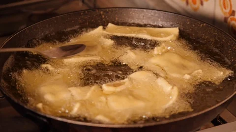 Cooking sweet in a pot with boiling oil - slow motion. Stock Footage 98685204