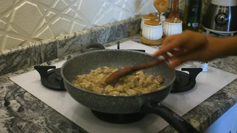 Cooking in th kitchen some chiken and onion in a pan with steam and good light Stock Footage 162913538