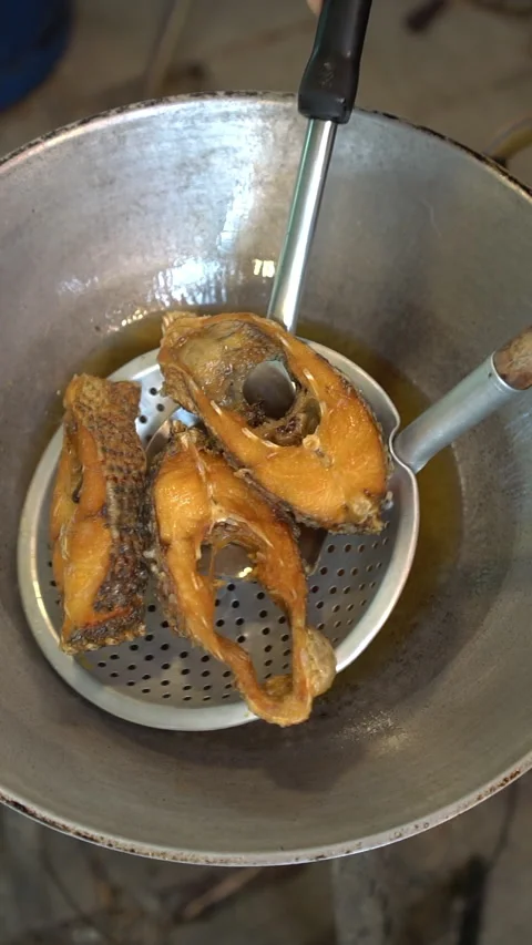 Cooking Thai food: deep-frying tilapia fish steaks and topping with sweet, sour, Stock Footage 342003459