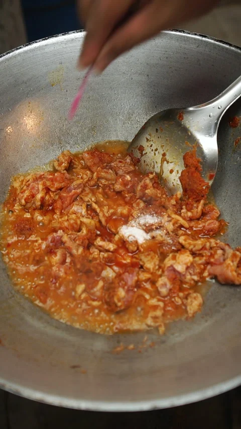 Cooking Thai stir-fried pork with red curry paste and long beans. Stock-Footage 336196282