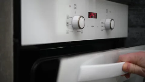 Cooking timer and oven settings being checked in a modern kitchen Stock Footage 304897150